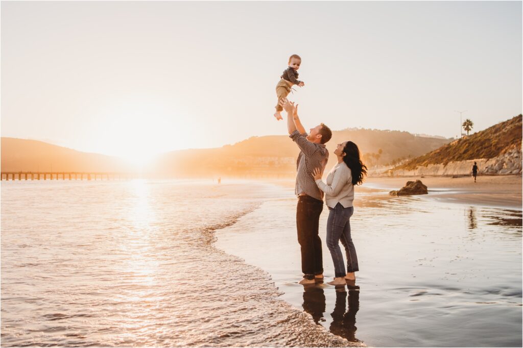 Family photography session at Avila Beach on the Central Coast with pier and shoreline at golden hour