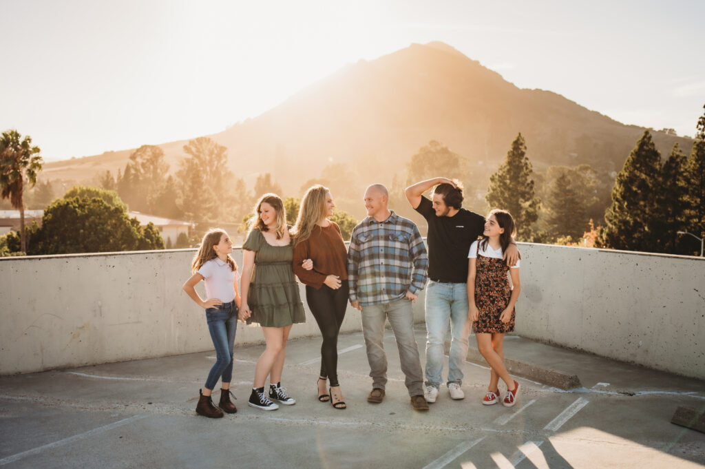 Family at the top of a parking garage in Downtown SLO with Bishop’s Peak in the background at sunset